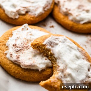five frosted pumpkin cookies set on a white background
