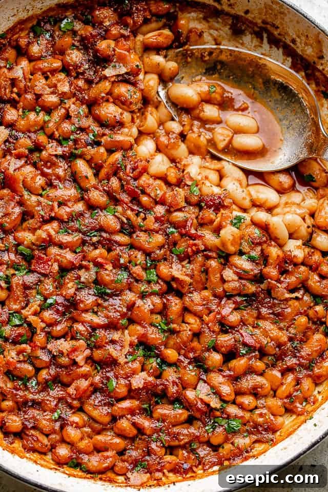 Homemade Maple Bacon Baked Beans: Sweet, Tangy, and a Little Spicy with Root Beer A rustic pot filled with homemade maple bacon baked beans, garnished with fresh parsley.