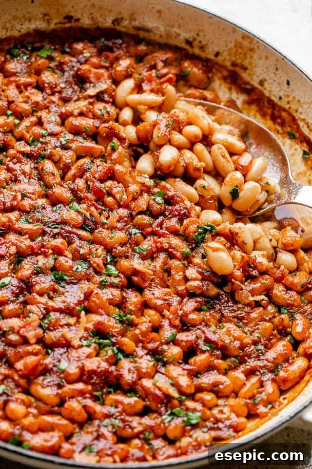 Serving Up Delicious Maple Bacon Baked Beans A serving spoon lifting a generous portion of baked beans from a rustic pot.
