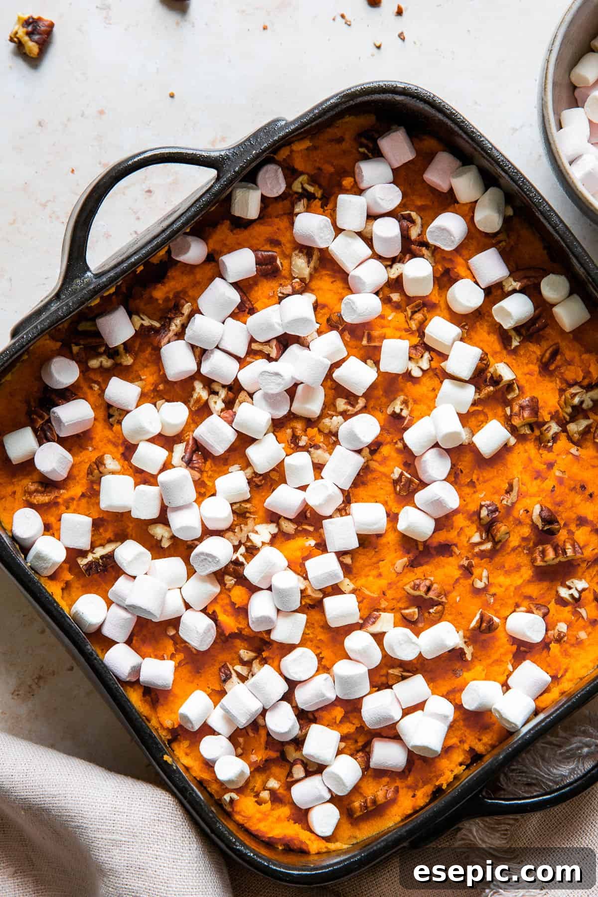 Golden Sweet Potato Delight 4 Close up shot of unbaked sweet potato casserole, sprinkled with pecans and mini marshmallows, ready for the oven.