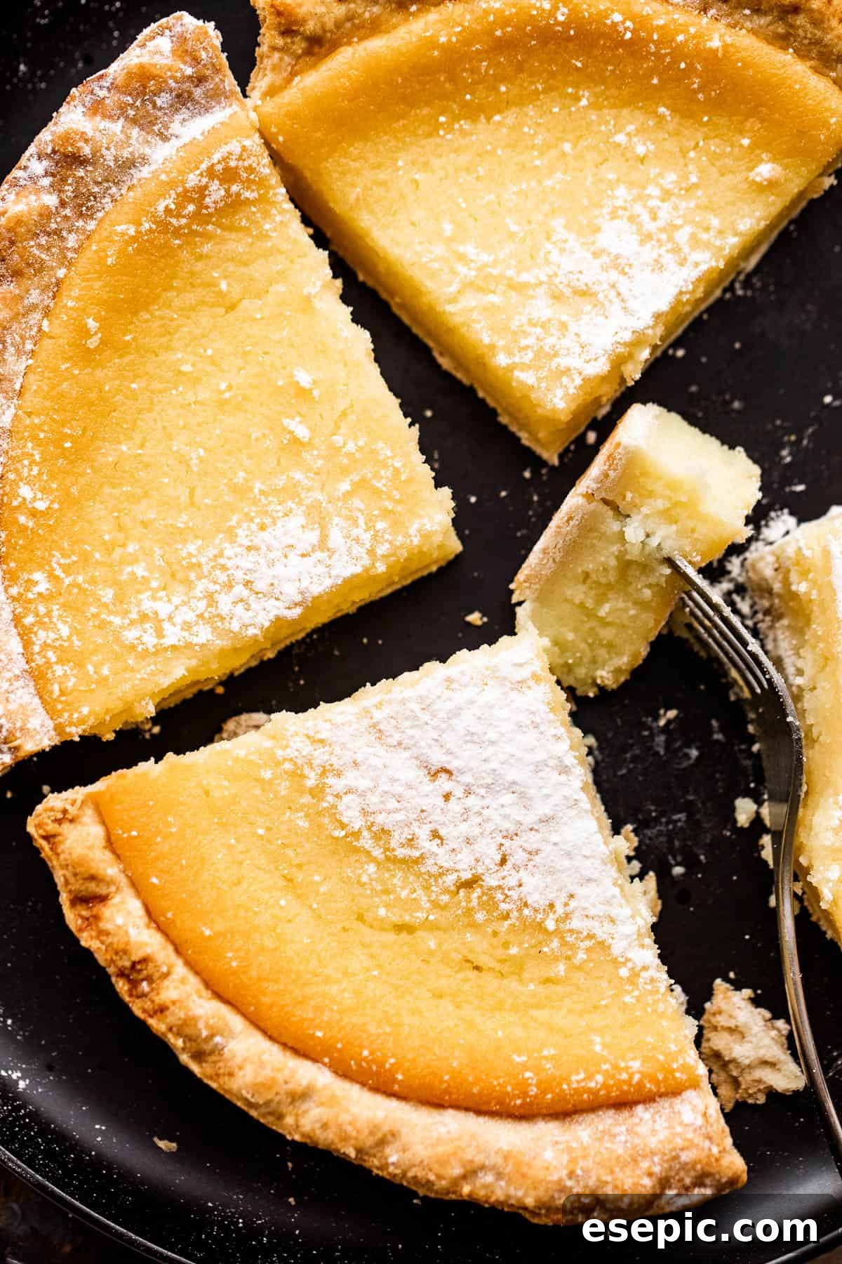 Close-up shot of a Southern Buttermilk Pie with a slice removed, revealing its smooth, golden custard texture and a perfectly baked crust.