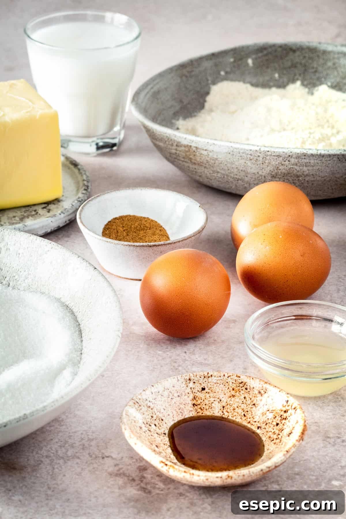 Clockwise from top left: Softened butter, creamy buttermilk, ground nutmeg, fresh eggs, all-purpose flour, vibrant lemon juice, pure vanilla extract, and granulated sugar, laid out as ingredients for buttermilk pie.