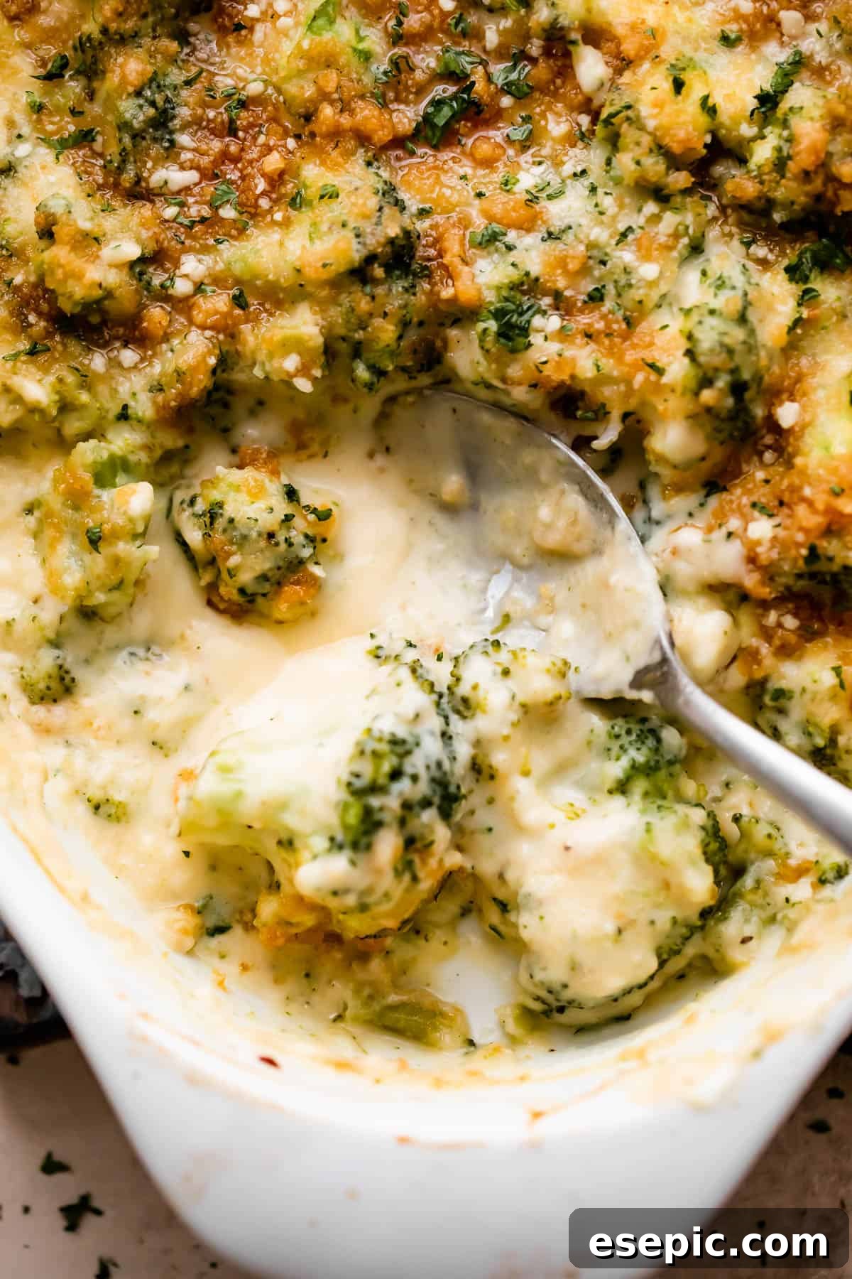 A wide overhead shot of a generous oval baking dish overflowing with golden-brown, bubbly Cheesy Broccoli Casserole, perfectly ready to be served, emphasizing its comforting appeal.