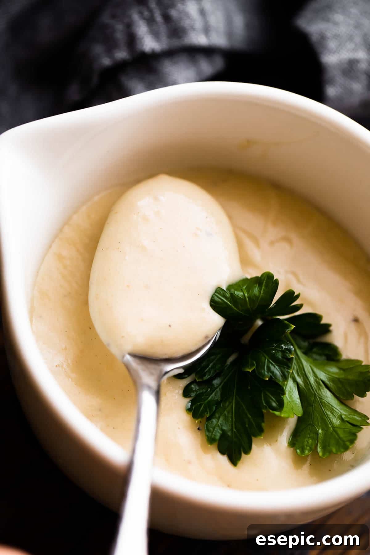 Velvety Creamy Chicken Soup 2 A comforting overhead shot of a white ceramic cup filled with thick, creamy homemade cream of chicken soup, garnished slightly.