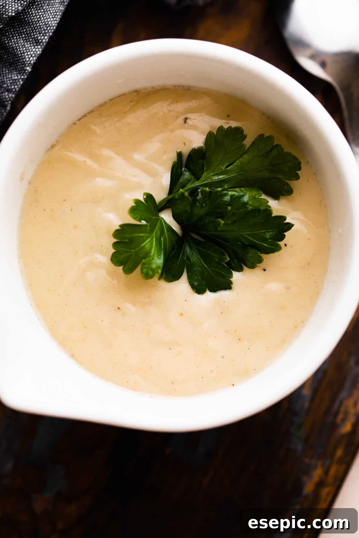 Velvety Creamy Chicken Soup 5 An inviting overhead shot of a white ceramic cup brimming with homemade cream of chicken soup, highlighting its rich, smooth texture.