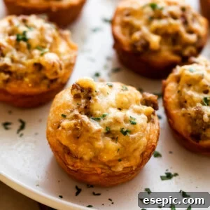 Savory Sausage Egg Muffins 2 Sausage breakfast cups arranged on a light plate and garnished with chopped parsley