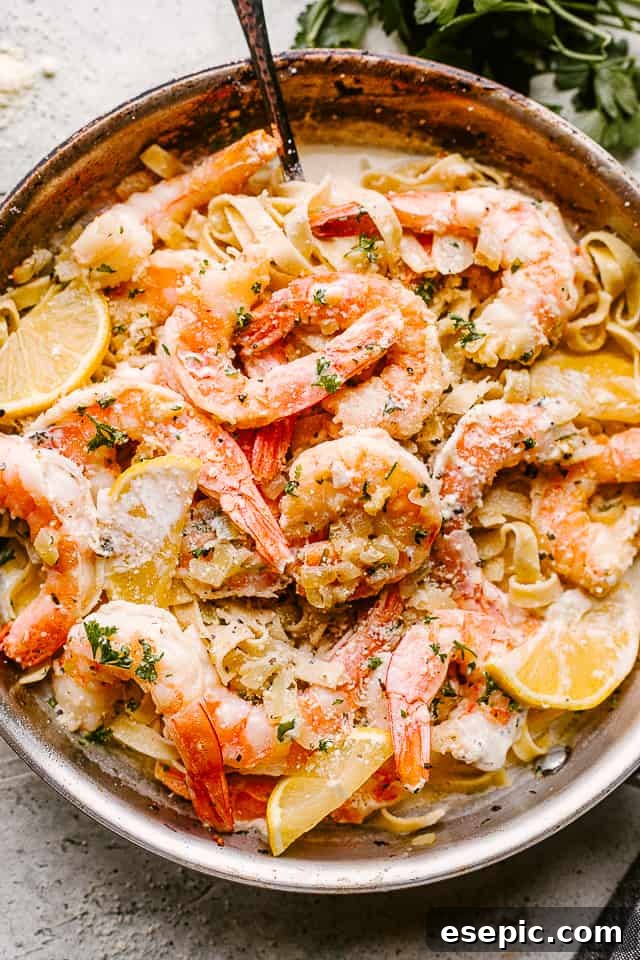 Decadent Shrimp Alfredo Delight 3 A vibrant, creamy shrimp Alfredo pasta dish, freshly tossed in a pan and ready to serve.