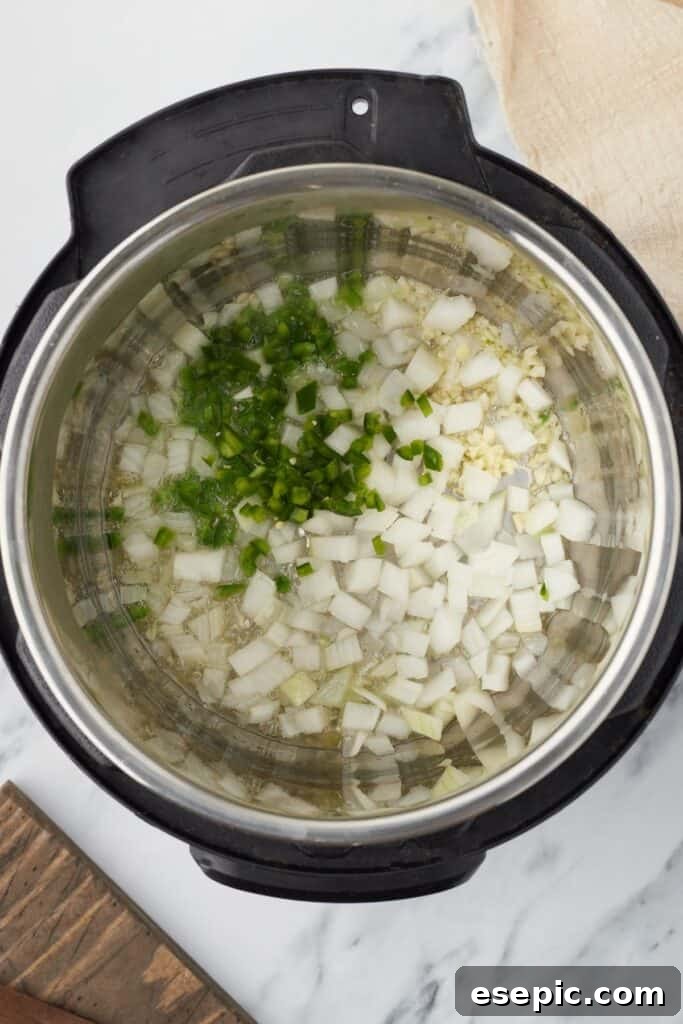 Overhead shot of an Instant Pot, with onions, garlic, and jalapeno inside.