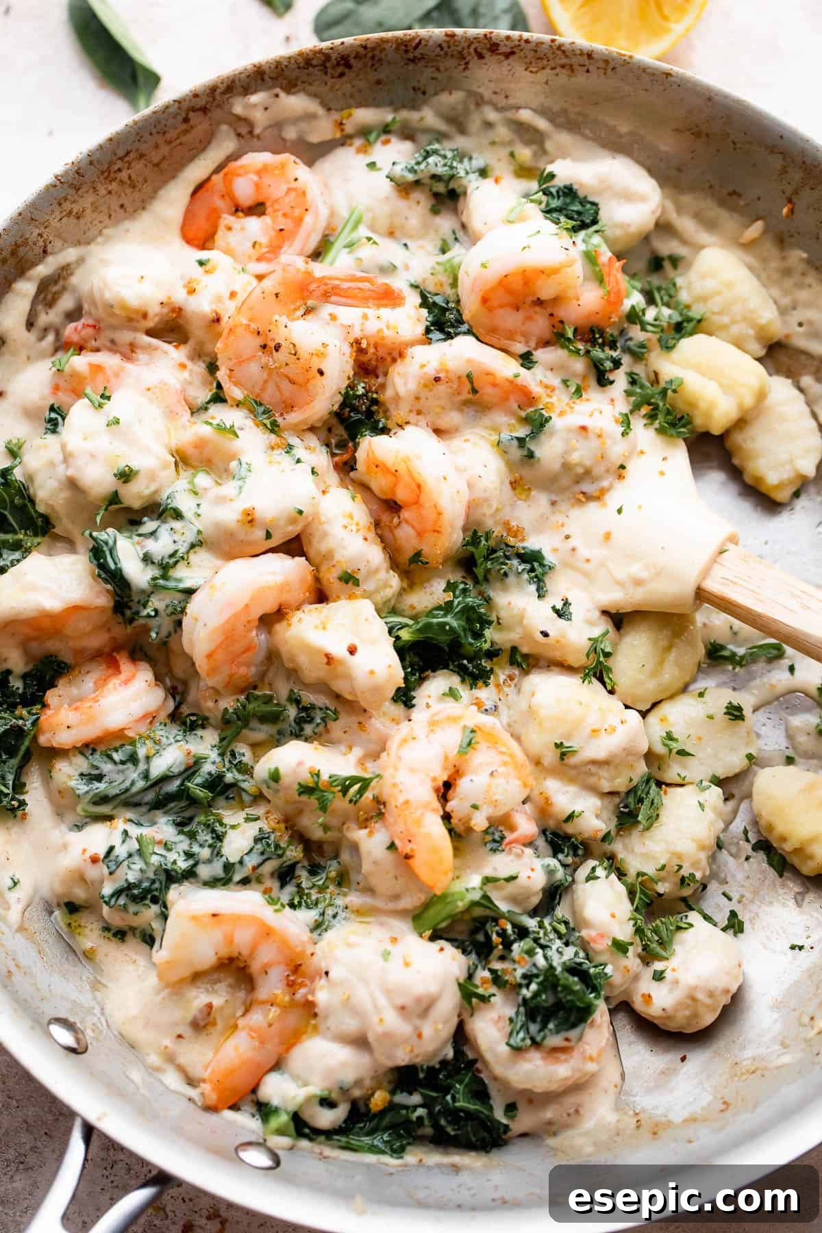 Velvety Parmesan Gnocchi with Succulent Shrimp 2 overhead shot of a steel skillet filled with gnocchi, shrimp, and greens.