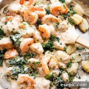 Velvety Parmesan Gnocchi with Succulent Shrimp 8 overhead shot of a steel skillet filled with gnocchi, shrimp, and greens.