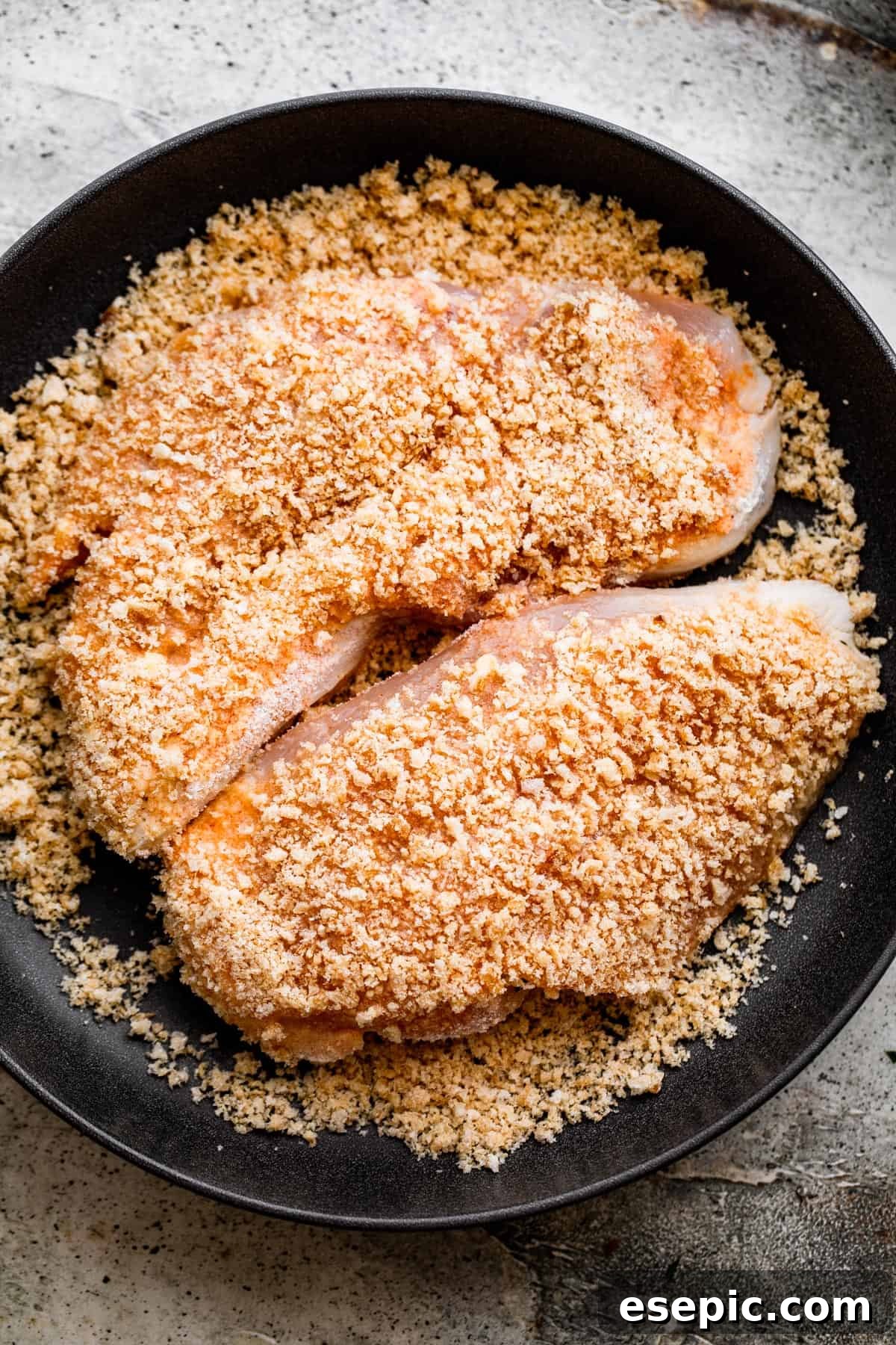 Perfectly Crispy Chicken Schnitzel 4 overhead shot of breaded chicken set on a black plate.