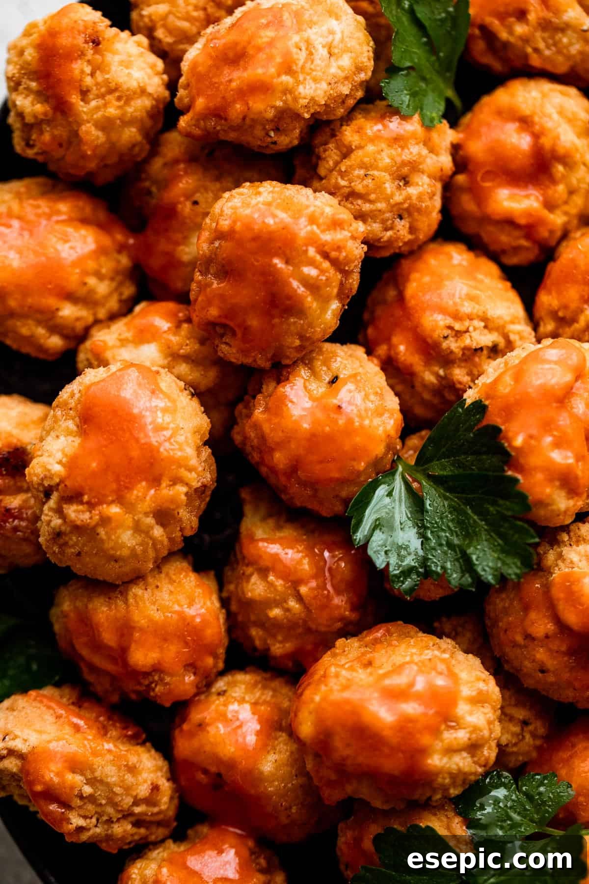 Close-up view of a pile of golden, perfectly fried popcorn chicken, highlighting its irresistible texture.