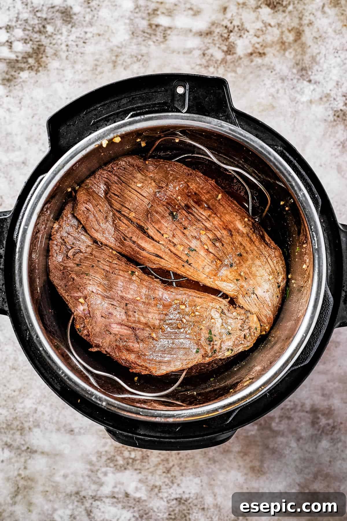 Flank steak actively browning inside an Instant Pot on the saute setting, showing a rich brown crust forming.