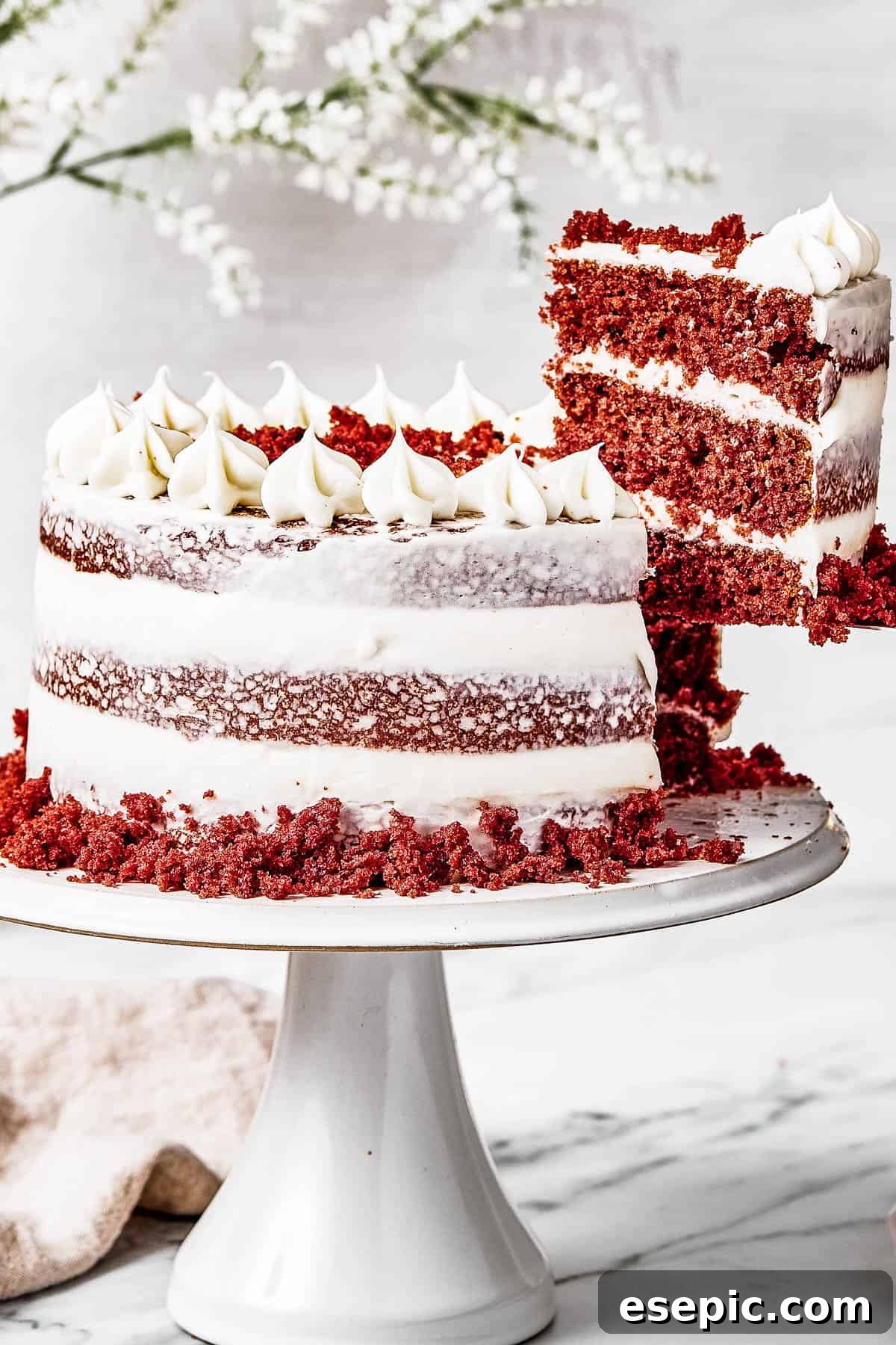 Decadent Red Velvet Dream 11 A woman's hand gently lifting a slice of vibrant Red Velvet Cake, displaying its beautiful layers and rich frosting.