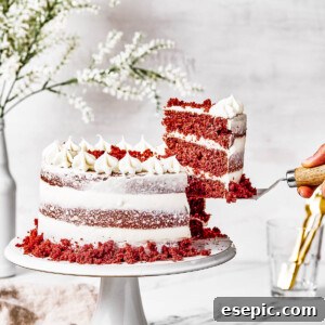 A woman's hand is lifting a slice of cake on a serving utensil.