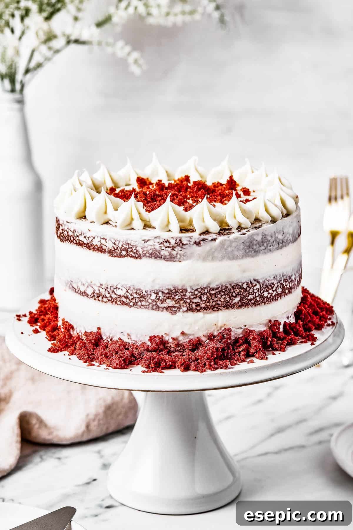 Decadent Red Velvet Dream 3 A beautifully frosted Red Velvet Cake sitting elegantly on a cake stand, ready to be served.