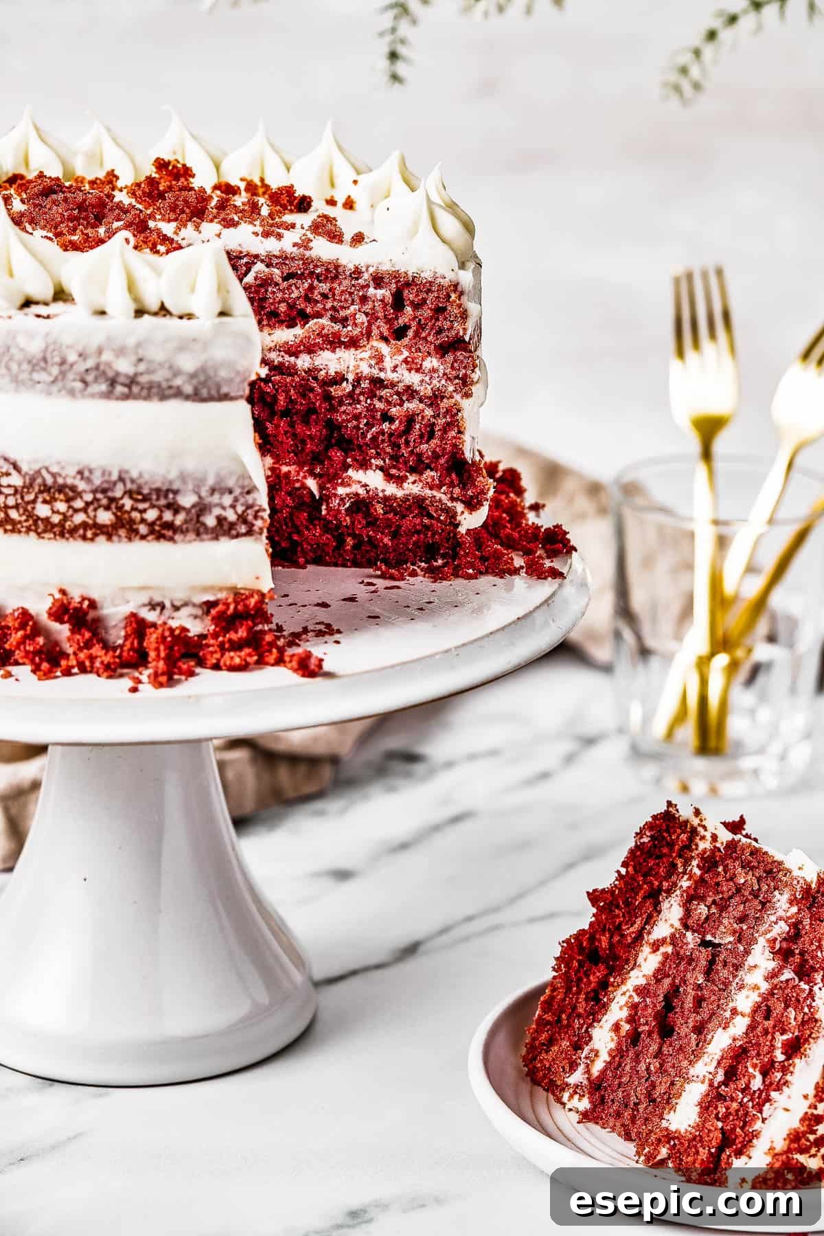 Decadent Red Velvet Dream 4 A beautifully presented Red Velvet Cake on a cake stand, with a slice already cut and placed on a small plate beside it, inviting indulgence.