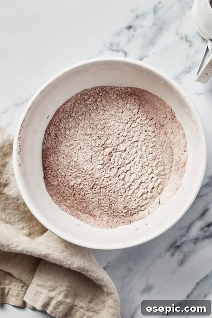 Decadent Red Velvet Dream 6 Dry ingredients for Red Velvet Cake, including flour, cocoa, salt, and baking soda, perfectly sifted together in a mixing bowl.