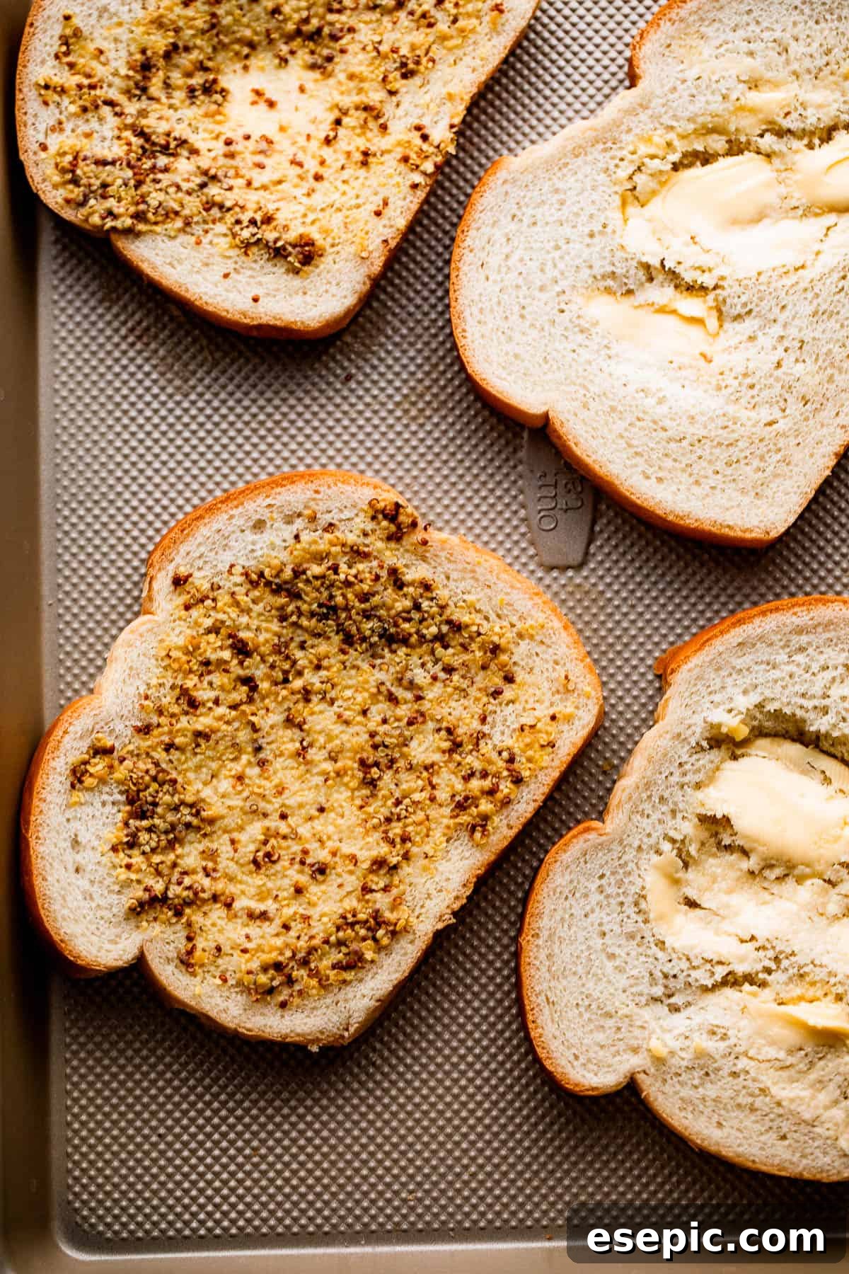 Golden Oven Baked Cheese Melts 4 Four slices of bread, each spread with a mixture of Dijon mustard and mayonnaise, ready for cheese.