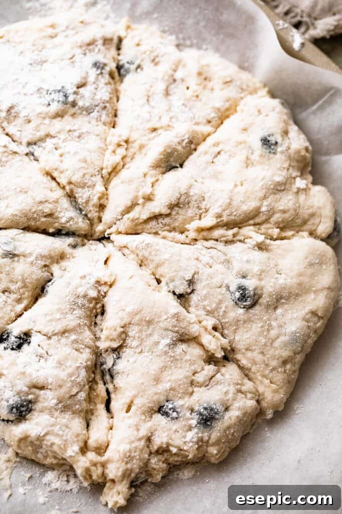 These Blueberry Scones are deliciously moist and easy to make with real, wholesome ingredients. a round loaf of dough cut into eight slices
