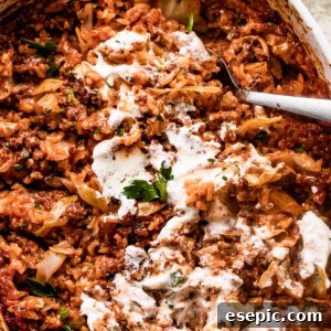 overhead shot of Cabbage Roll Casserole in a white baking dish, and the casserole is smothered with sour cream on top.