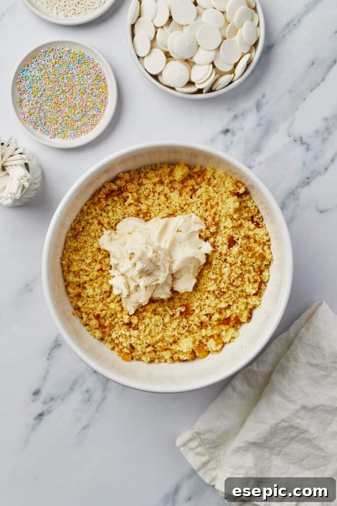 Cake crumbs and frosting expertly blended in a mixing bowl, ready to be formed into balls.