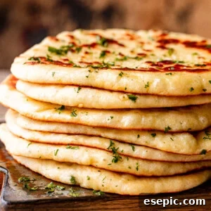 Stack of homemade flatbread on a wooden board.