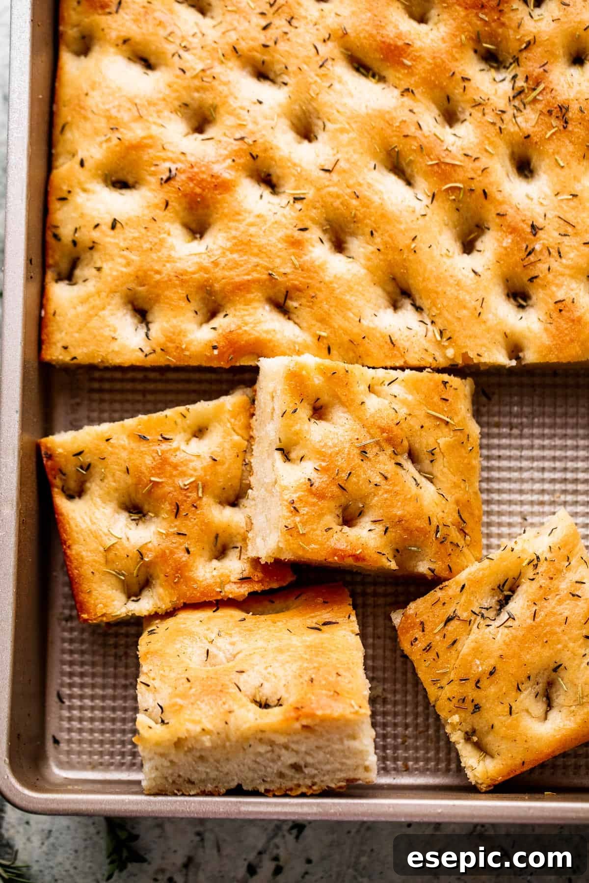 Aromatic Garlic and Herb Focaccia 8 An overhead shot of a freshly baked focaccia loaf, golden and glistening with olive oil and herbs, sliced and ready to serve.