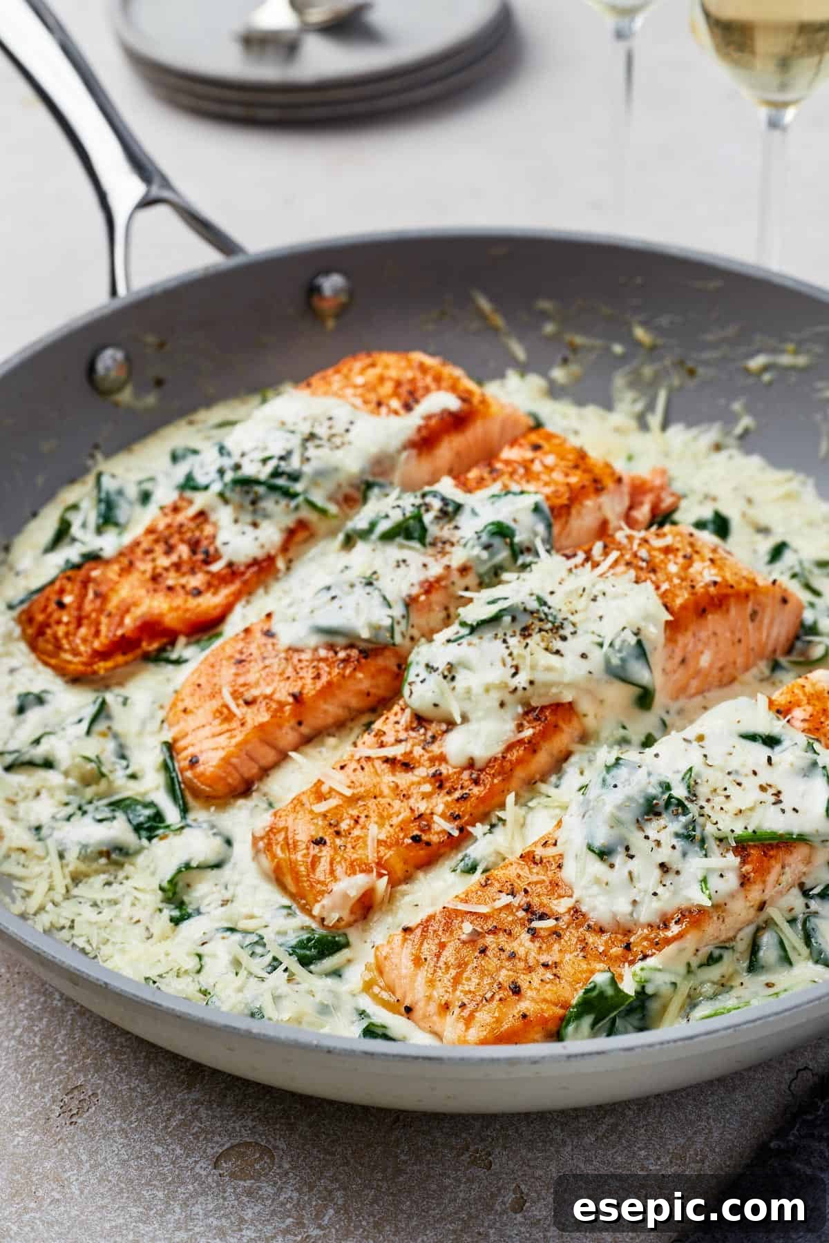 A close-up view of pan-fried salmon fillets bathed in the rich, creamy Florentine sauce, ready to be served.