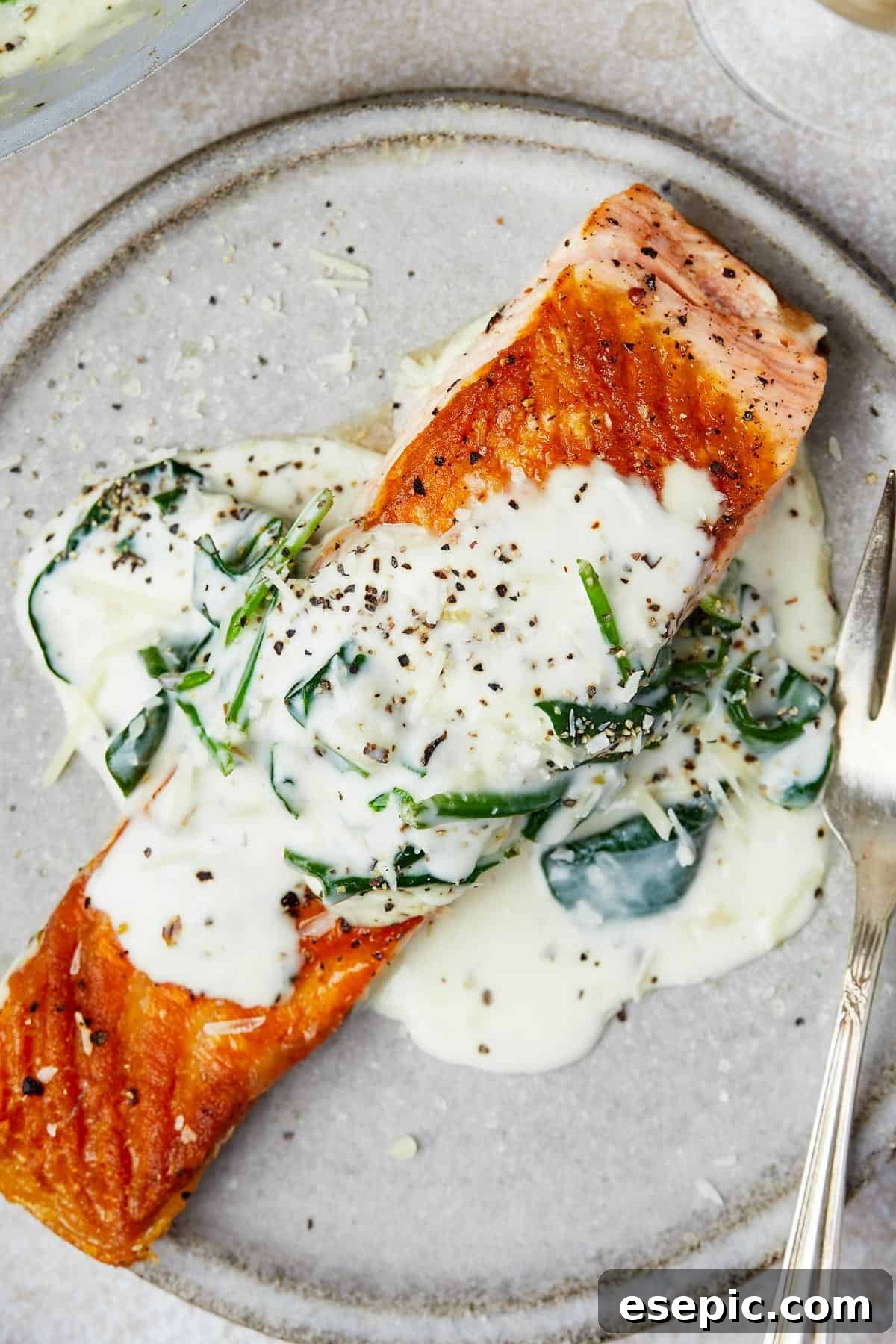 A single serving of Salmon Florentine beautifully plated, showcasing the rich salmon fillet topped with creamy spinach sauce.