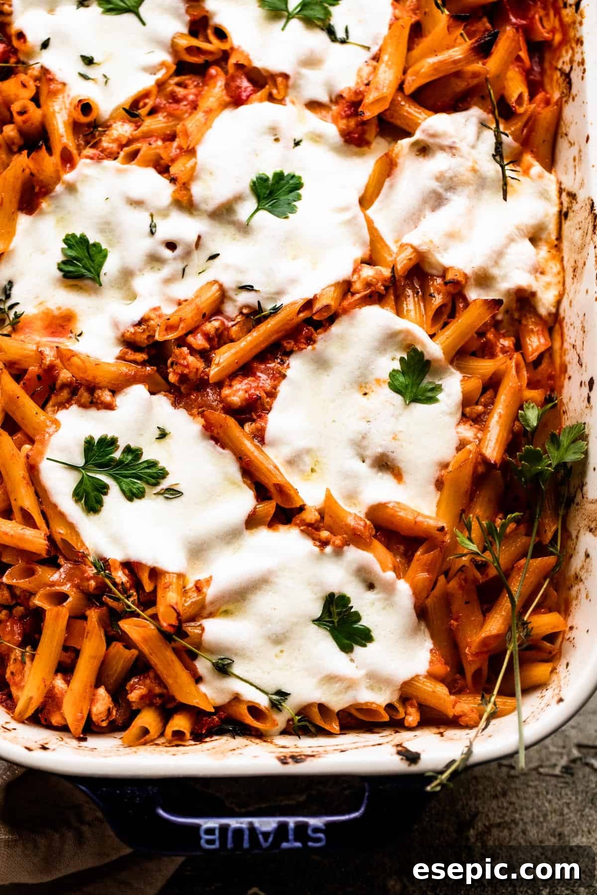 overhead close up shot of a baking dish with Baked Penne Alla Vodka topped with melted mozzarella cheese.