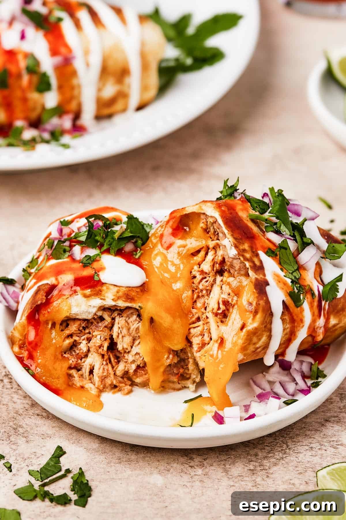 Golden Fried Chicken Chimichangas from Scratch 2 A plate with a chimichanga cut in half to show the filling, garnished with fresh cilantro.