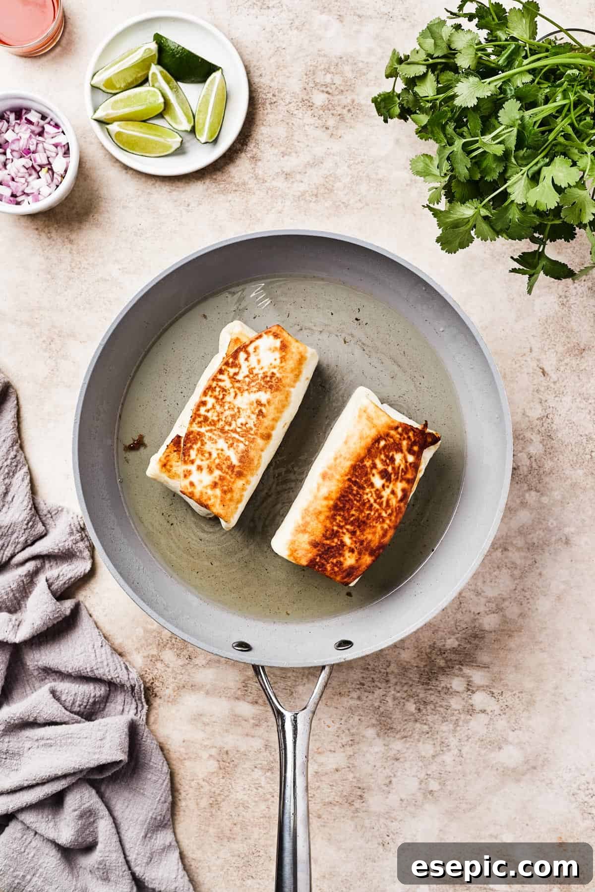 Golden Fried Chicken Chimichangas from Scratch 7 Fried burritos cooking in a skillet with hot oil, turning golden brown.