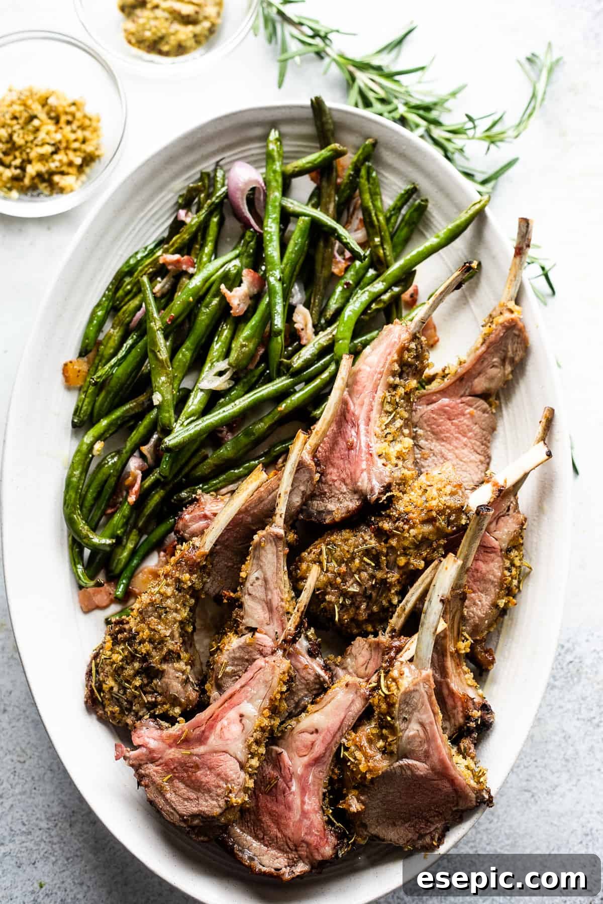 The Definitive Rack of Lamb 5 overhead shot of lamb chops arranged on a serving platter with a side of green beans placed above the chops.