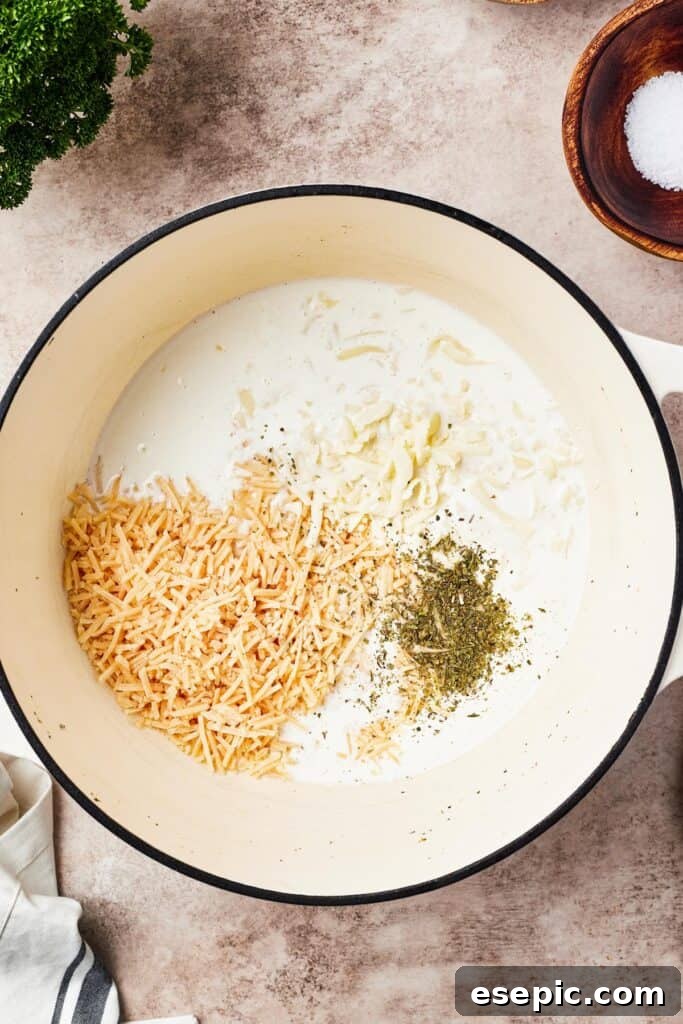 Alfredo sauce being whisked in a large pot on the stovetop, creating a smooth and creamy texture.