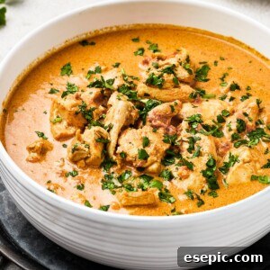 Chicken curry in a white enamel bowl.