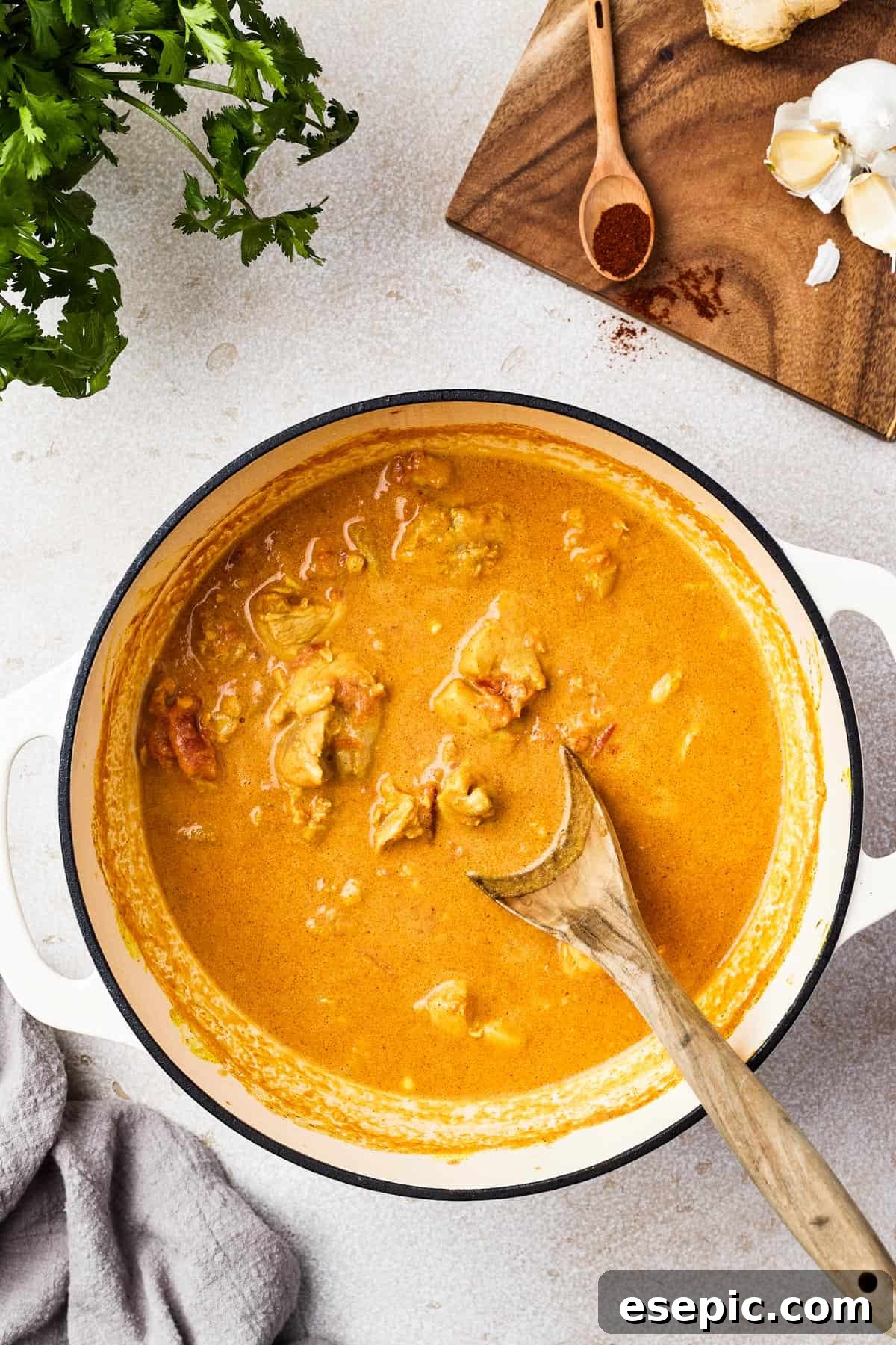 A large, heavy pot filled with rich, creamy chicken curry, ready to be served.