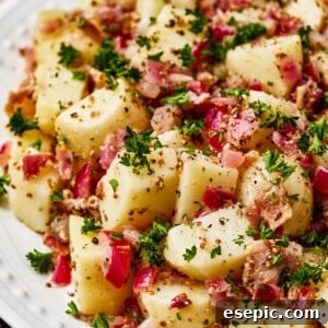 Warm German Potato Salad with Bacon 11 Close-up shot of chopped, boiled potatoes tossed with bacon and dressing.