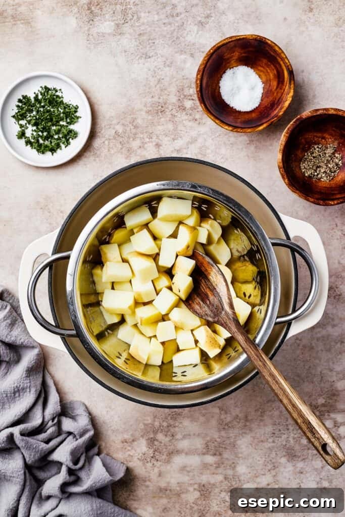 Warm German Potato Salad with Bacon 6 Potatoes boiling in a large pot, with dishes of parsley, salt, and pepper arranged on the work surface, indicating readiness for seasoning and garnishing.