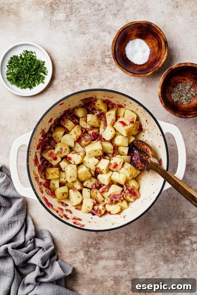 Warm German Potato Salad with Bacon 8 Potatoes thoroughly mixed with crispy bacon and the tangy vinaigrette dressing in a large pot, ready to be served.