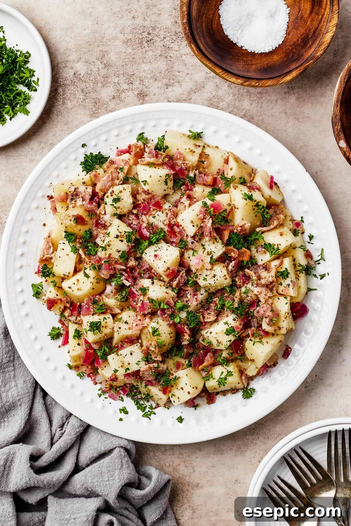 Warm German Potato Salad with Bacon 9 A beautifully plated serving of warm potato salad, garnished with fresh herbs and crumbled bacon, emphasizing its delicious appeal.