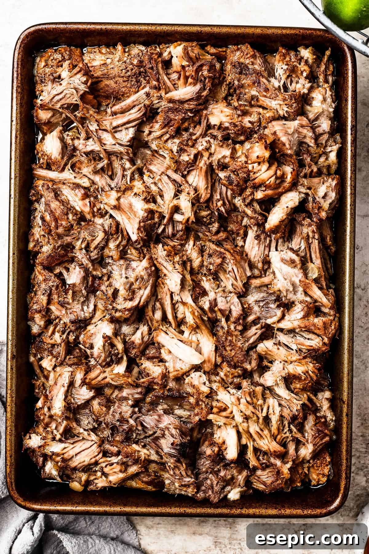 Beautifully browned shredded pork spread out on a baking sheet, showcasing its crispy texture.
