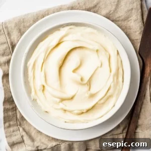 A bowl of creamy white icing on a linen napkin.