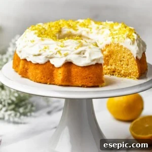A lemon Bundt cake on a platter, with one slice cut out, ready to be served.