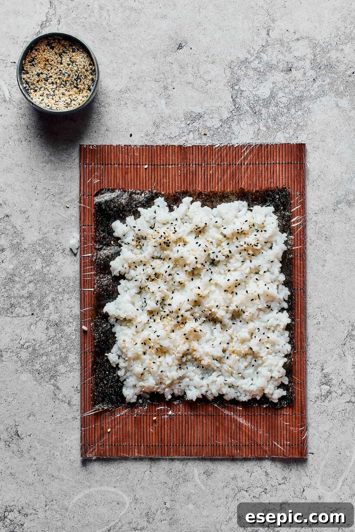 A sheet of nori with sushi rice spread over it.