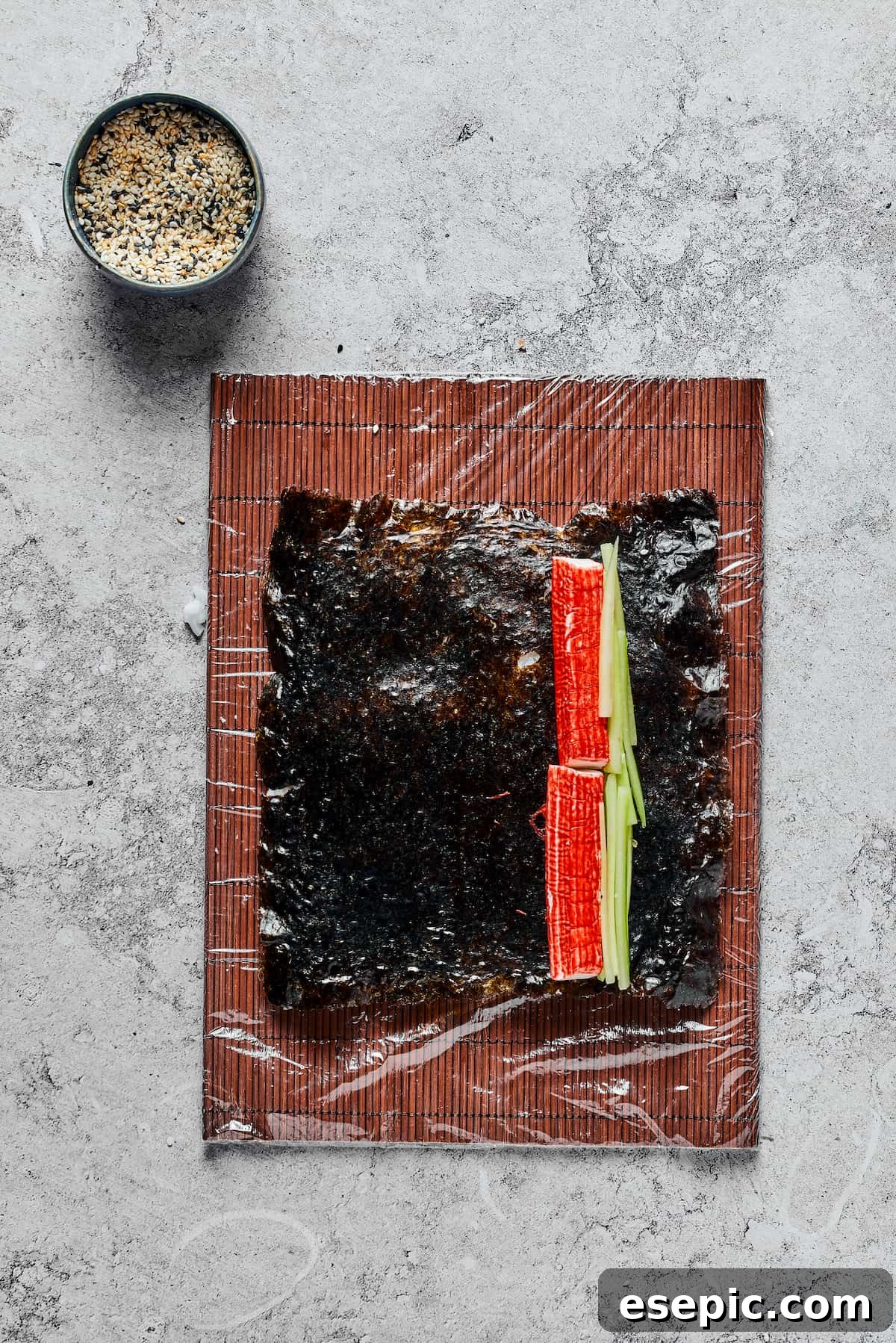 A sheet of nori with surimi (imitation crab) slices and cucumber slices on one side.