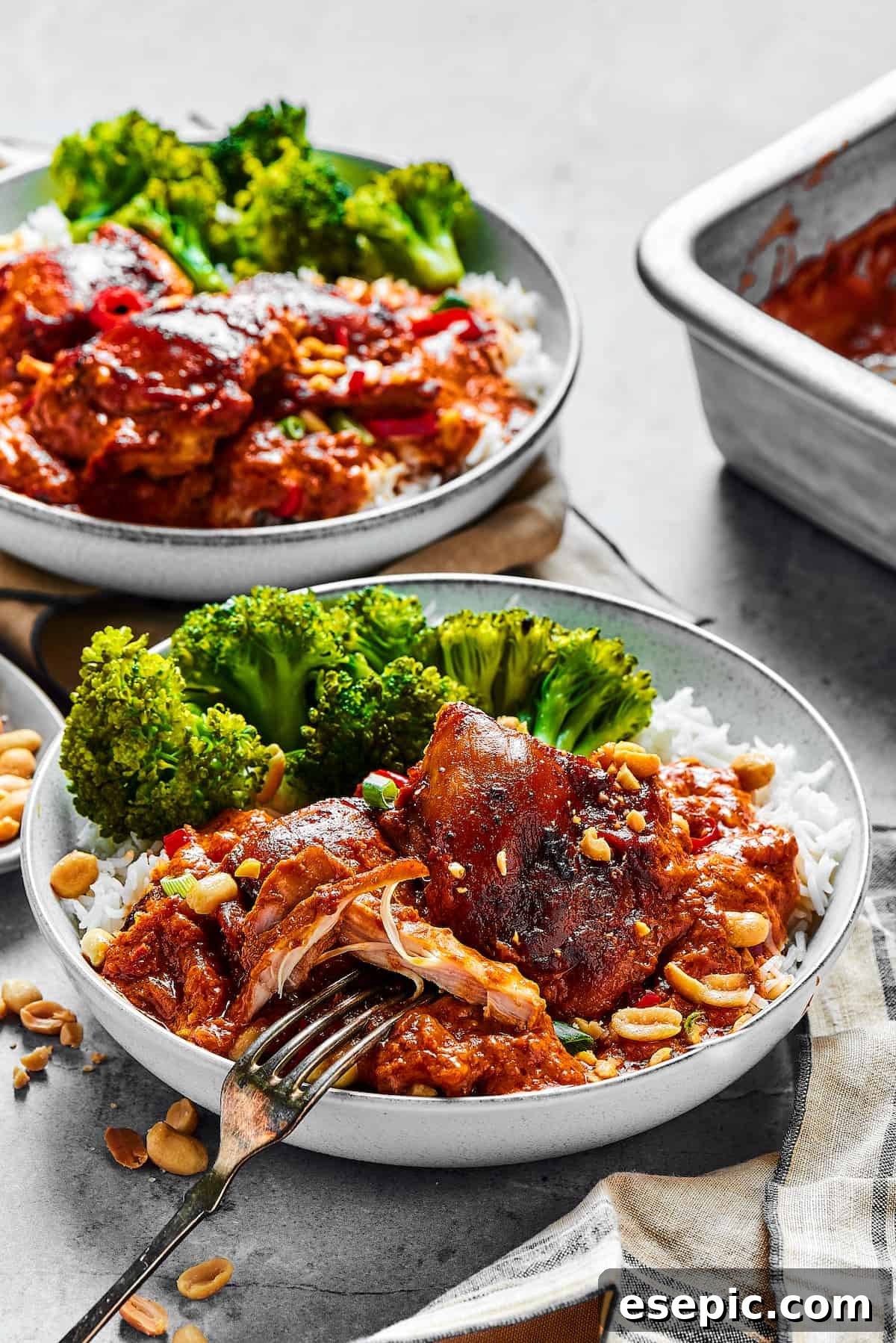 Simple Peanut Butter Chicken - Easy, Healthy, and Flavorful! Two plates of saucy chicken and veggies.