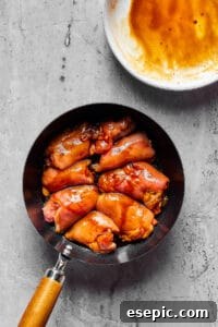 Creamy Peanut Chicken Delight 4 Chicken thighs cooking in a skillet.
