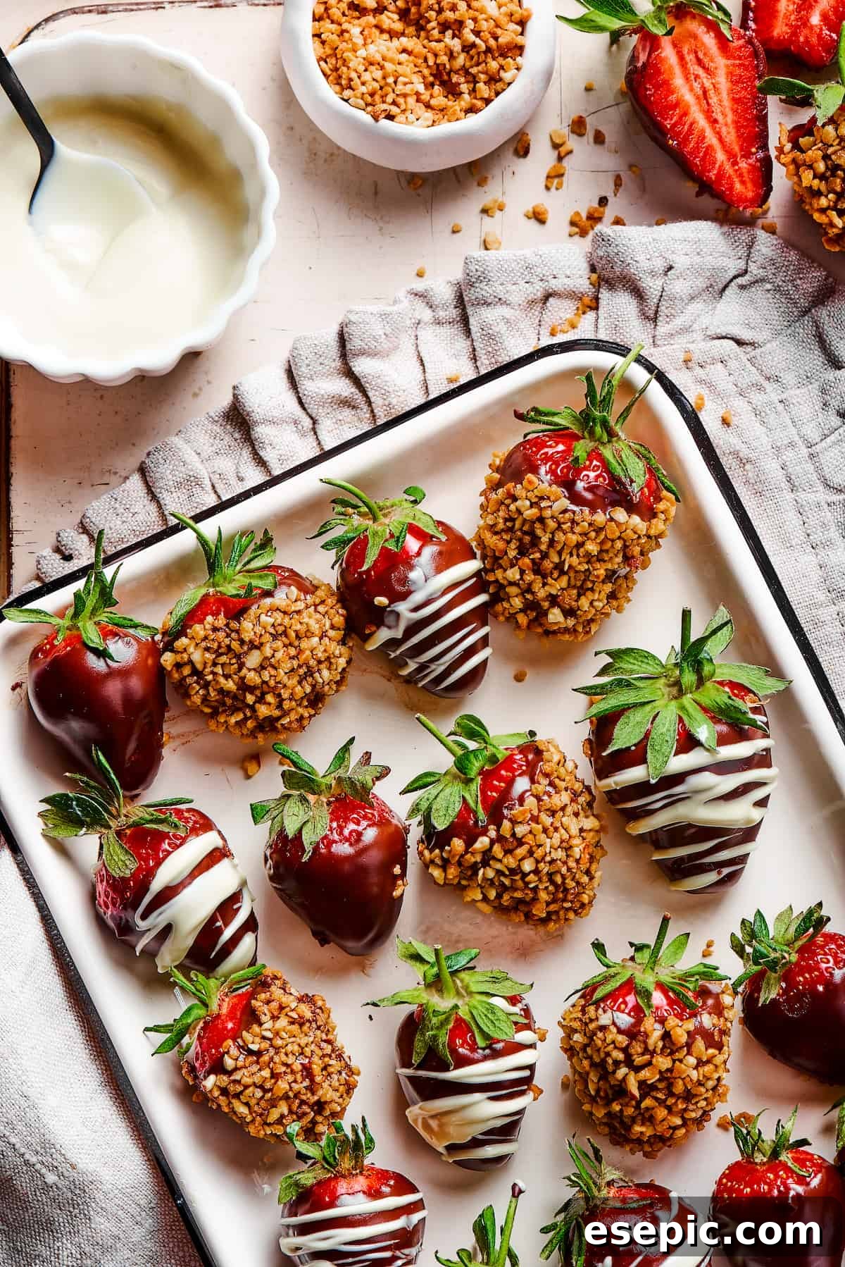 Effortless Chocolate Strawberry Delight 2 A elegant white tray with a black border, showcasing three exquisite variations of chocolate-dipped strawberries: plain, with a white chocolate drizzle, and coated in toasted hazelnuts.