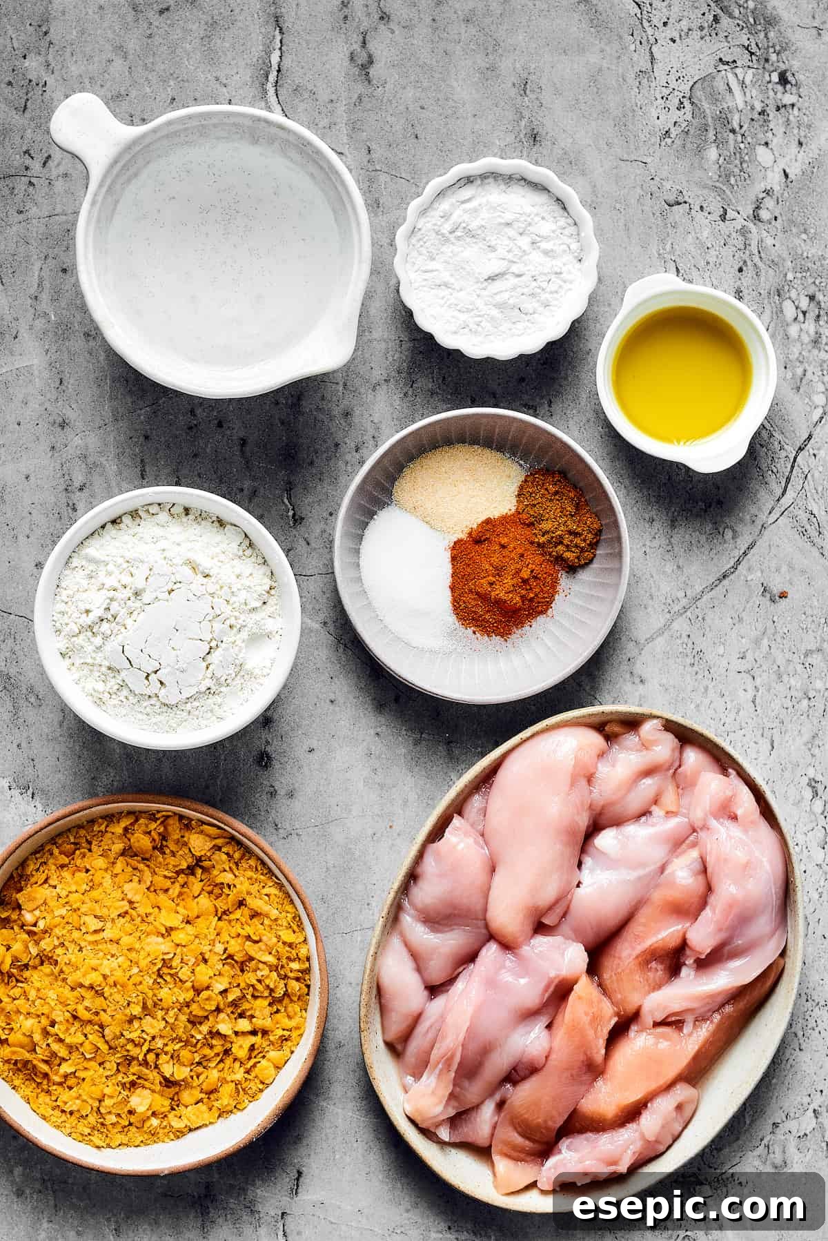 Utterly addictive, this easy recipe for Air Fryer Chicken Tempura is a favorite! Tender, juicy chicken strips are coated in a light and crispy batter, and then air-fried to golden perfection. From top: Water, tapioca flour, olive oil, all-purpose flour, seasonings, corn flakes, chicken breast strips.